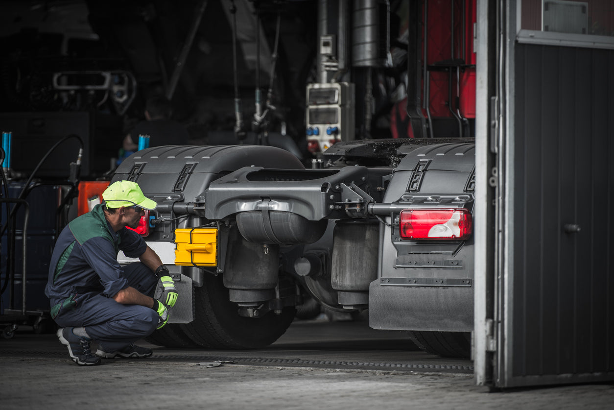 Service technician inspecting the Volvo truck parts at the back of the truck’s cab